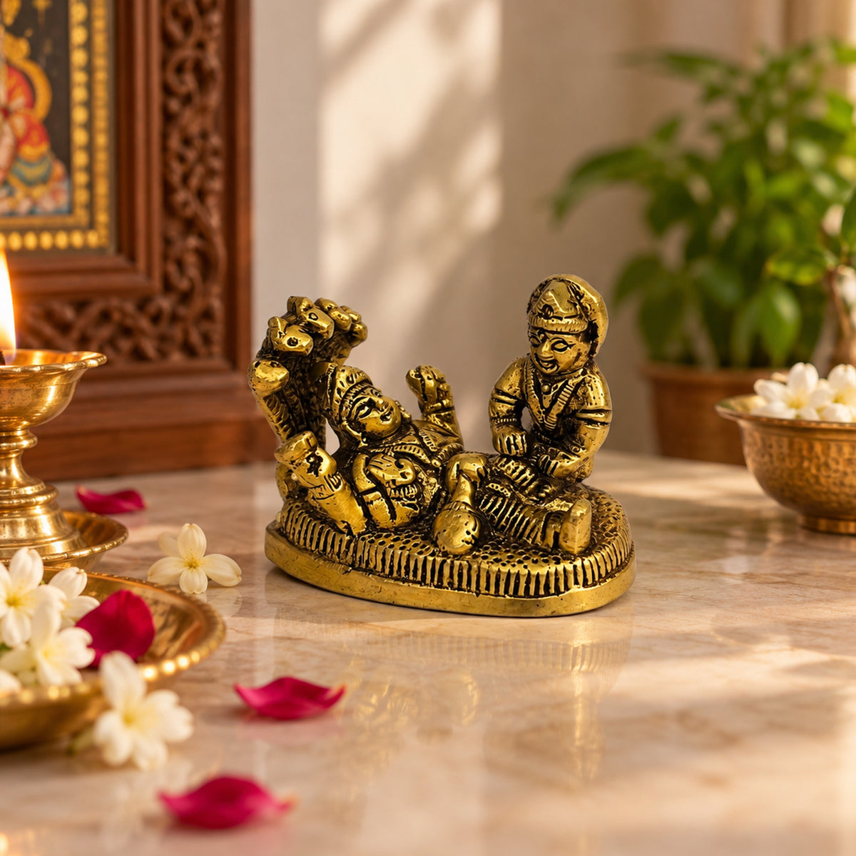 Brass Vishnu Lakshmi statue displayed in a puja setting