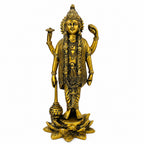 Lord Vishnu brass idol — rear view on wooden surface with diya and marigolds