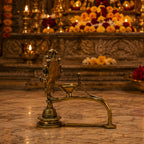 Brass Seshnag Diya – side view in temple setting with marigold flowers and diyas